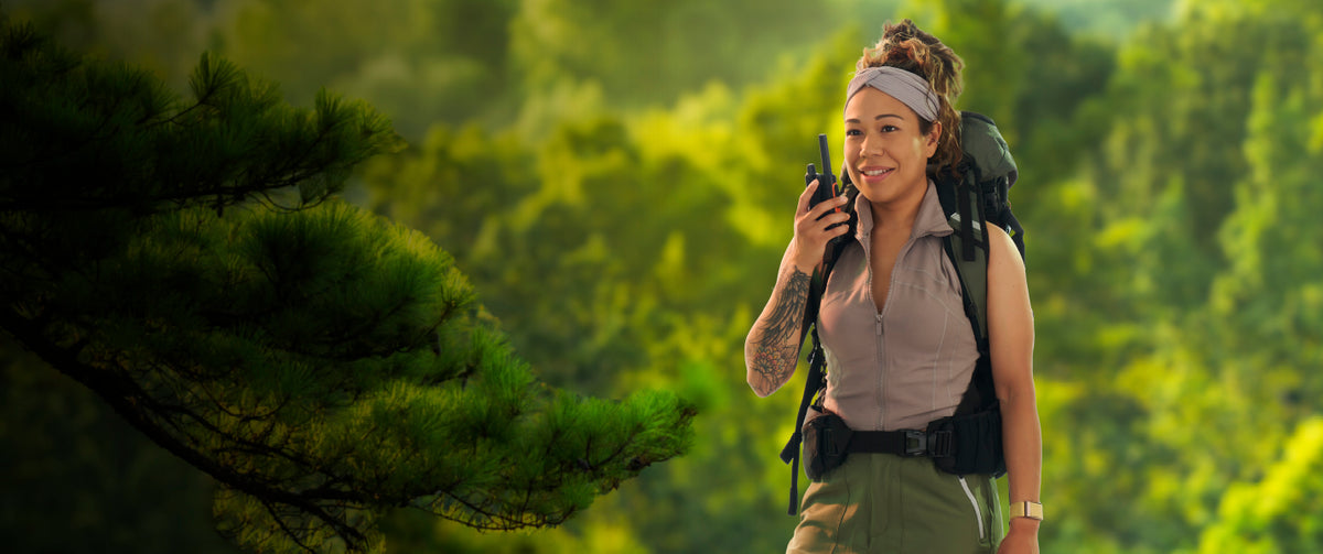 Woman with a backpack and walkie-talkie in a forest setting